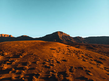 Scenic view of desert against clear blue sky