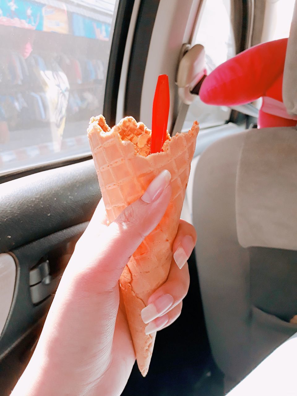 human hand, hand, human body part, real people, one person, frozen, holding, mode of transportation, vehicle interior, frozen food, food and drink, ice cream, food, motor vehicle, car, sweet food, sweet, transportation, lifestyles, finger, ice