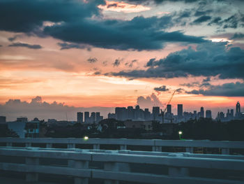 Modern buildings in city against sky during sunset
