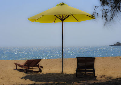 Lifeguard chair on beach against sky