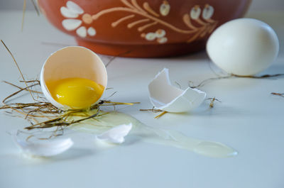 White egg is broken, the shell is on the table. light background