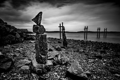 Cross on beach against sky