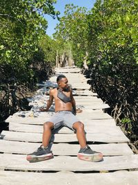 Portrait of woman sitting on boardwalk