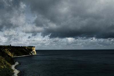 Scenic view of sea against storm clouds