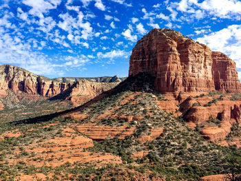 Rock formations on landscape against cloudy sky