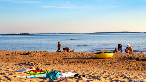 People on beach against sky