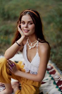 Portrait of young woman sitting on field