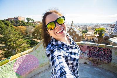 Portrait of smiling young man standing against cityscape