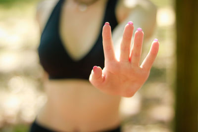 Midsection of woman gesturing stop gesture at park