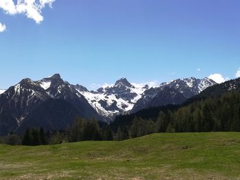 Scenic view of snowcapped mountains against blue sky