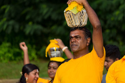 Portrait of smiling man holding yellow while standing outdoors