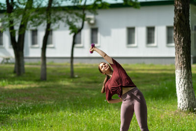 Full length of woman holding umbrella on field