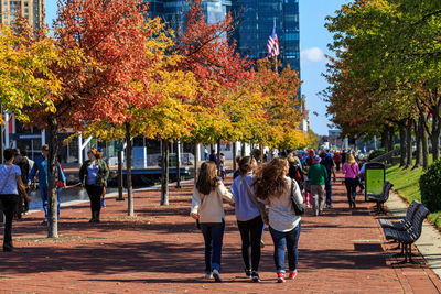 Group of people walking on sidewalk in city