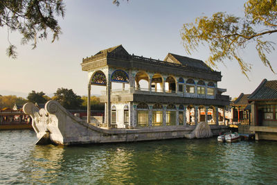 View of building by lake against sky