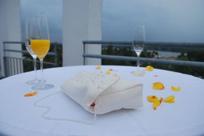 Close-up of white purse on table with drinks