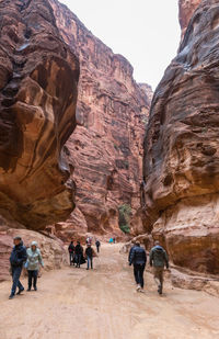 Rear view of people walking on rock