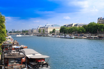 Boats in river against buildings in city