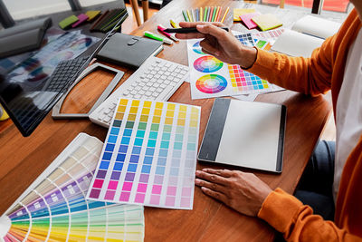 Midsection of creative occupation woman using graphics tablet sitting on table