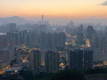 Aerial view of buildings in city against sky during sunset