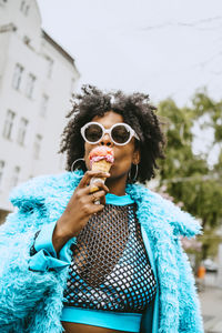 Young hipster woman with fur jacket eating ice cream