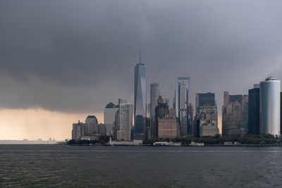 Modern buildings in city against cloudy sky