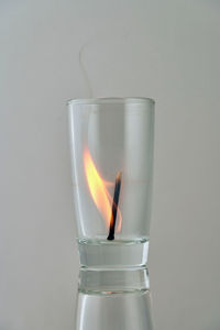 Close-up of burning candle against black background