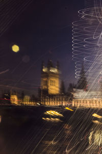 Digital composite image of illuminated cityscape against sky at night