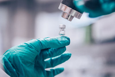 Cropped hand of scientist holding vial in laboratory