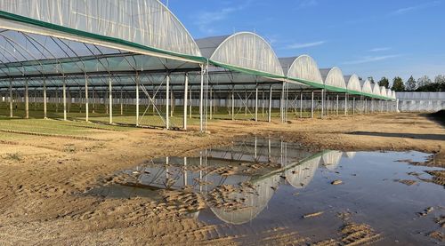 Arch bridge in greenhouse against sky