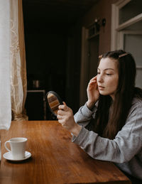 Young woman using mobile phone at home