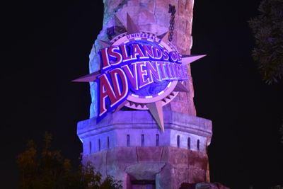 Low angle view of illuminated text against clear sky at night