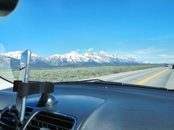 Close-up of car on road against mountain range