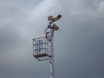 Traffic surveillance cctv camera on high tower pole and dramatic grey sky background