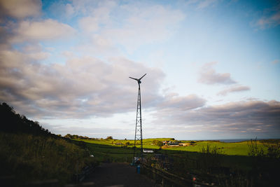 Street amidst field against sky
