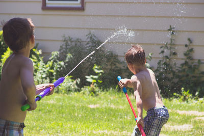 Children playing with water in yard