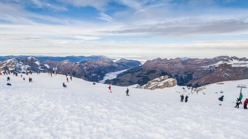 People on snow covered mountain against sky