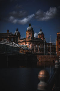 Illuminated buildings in city at night by the river