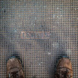 Low section of person with text on tiled floor