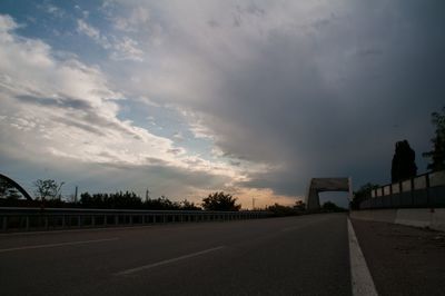 Empty road against cloudy sky