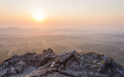 Rock formation on landscape against sky during sunset