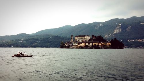 Boats in sea with mountains in background