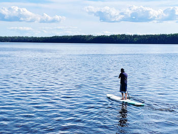 Man surfing in lake against sky