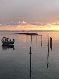 Sunset with boat in harbour on still water