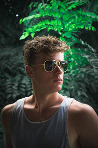 Portrait of young man wearing sunglasses standing outdoors