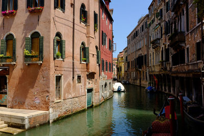 Boats moored in grand canal amidst old buildings