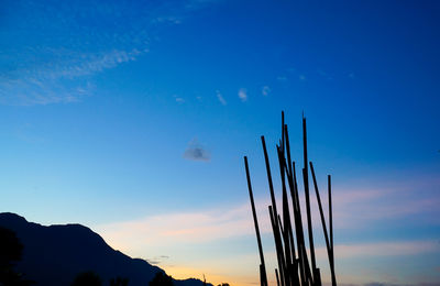 Low angle view of silhouette wooden post against sky during sunset