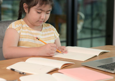Close-up of girl studying at table