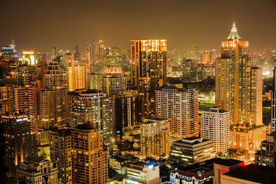 Illuminated cityscape against sky at night