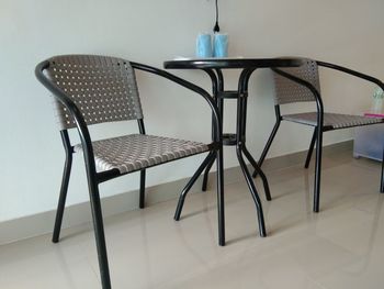 Empty chairs and table against wall at home