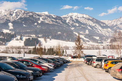 Cars on snow covered mountain against sky